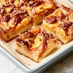 Thickly sliced squares of keto peach pecan cake showing a soft crumb and peach topping