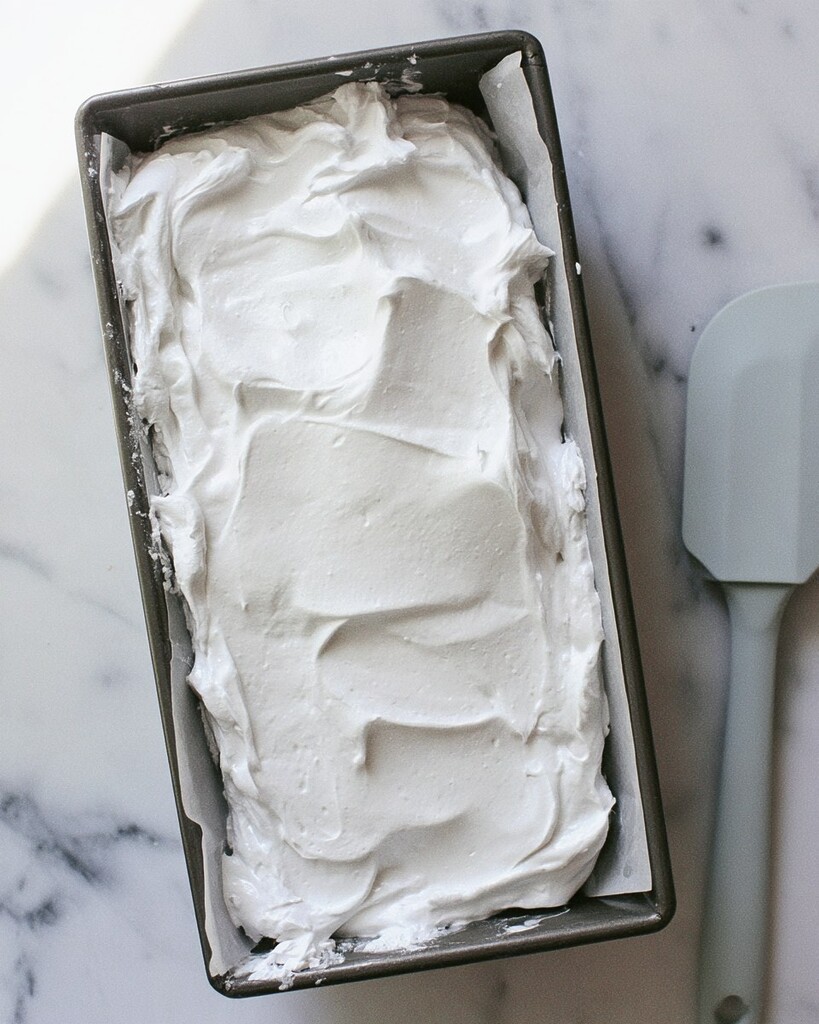 Thick white marshmallow mixture spread evenly into a parchment-lined loaf pan
