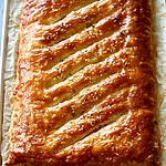 Maple-Dijon Ham and Gruyère Puff Pastry Slab Golden brown baked puff pastry slab on a parchment-lined baking sheet.