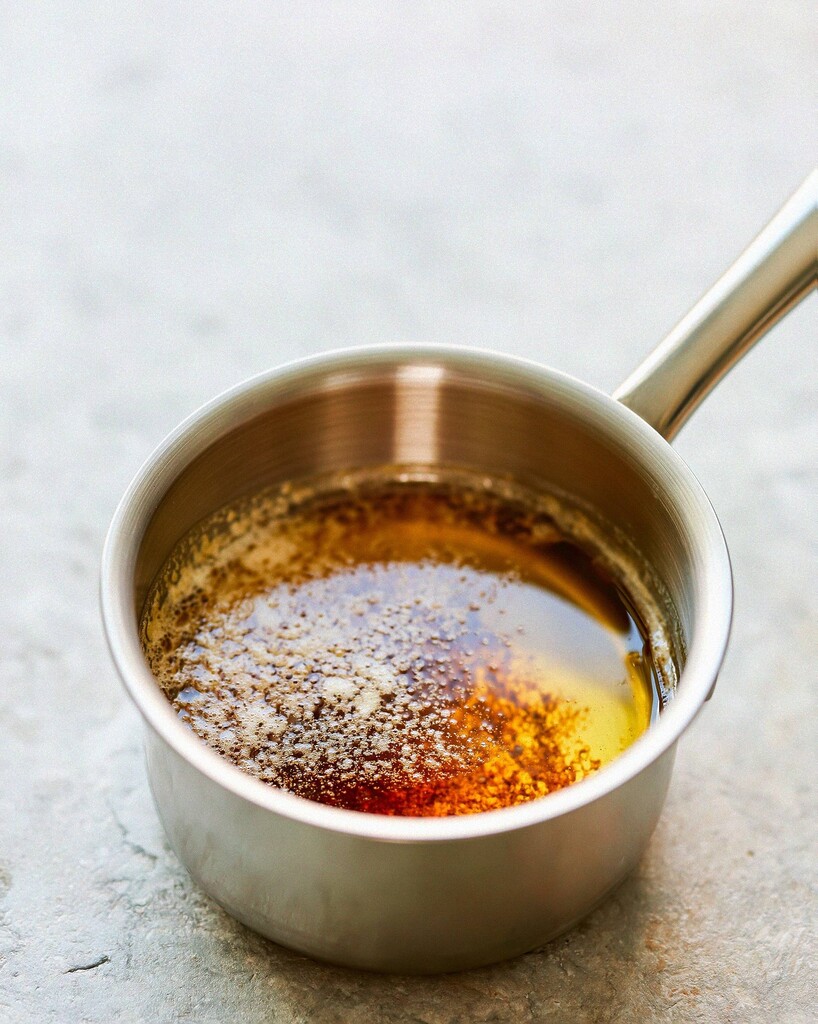 Melted butter foaming in a saucepan with toasted golden flecks at the bottom