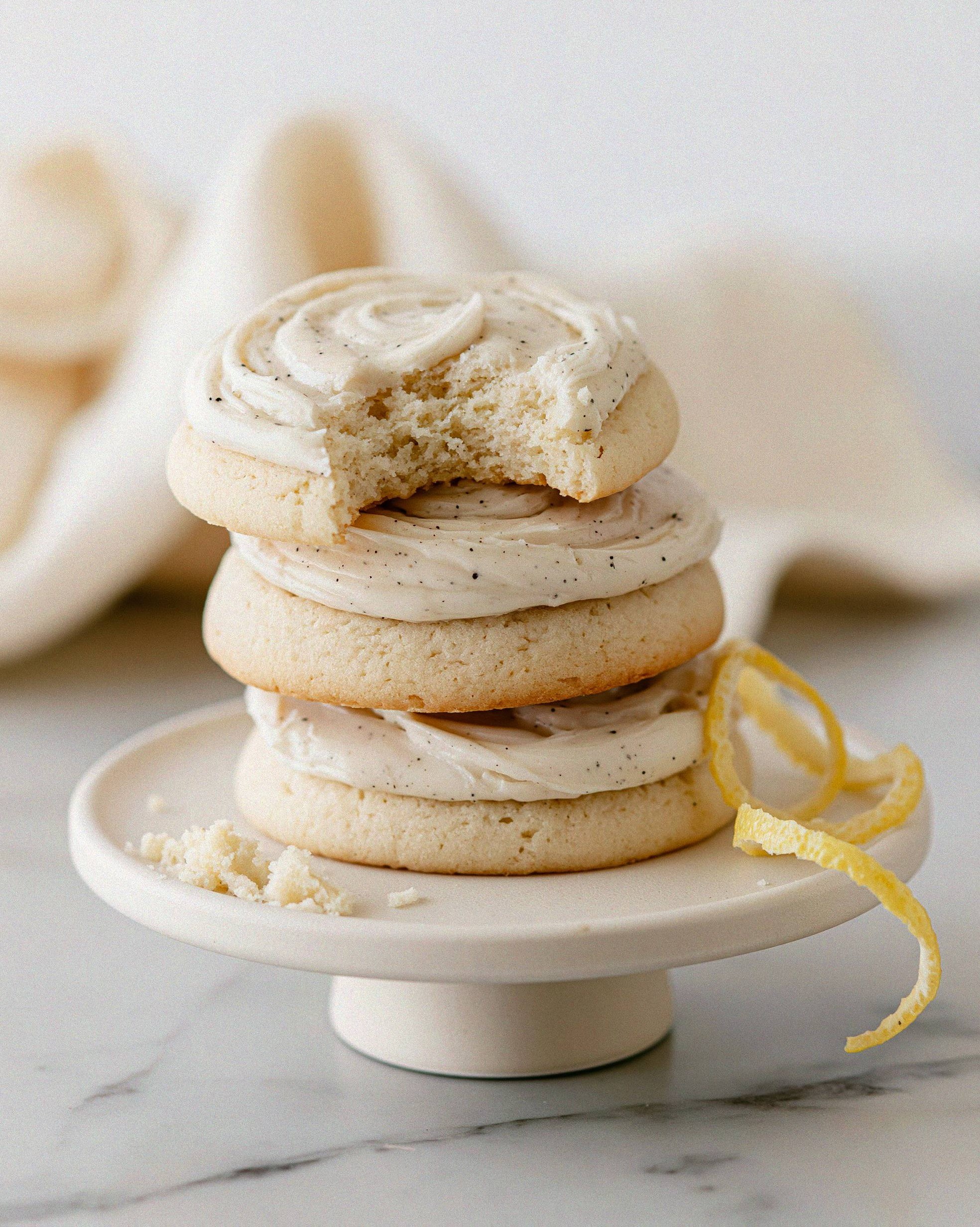 Stack of vanilla glazed lemon meltaway cookies on a ceramic stand