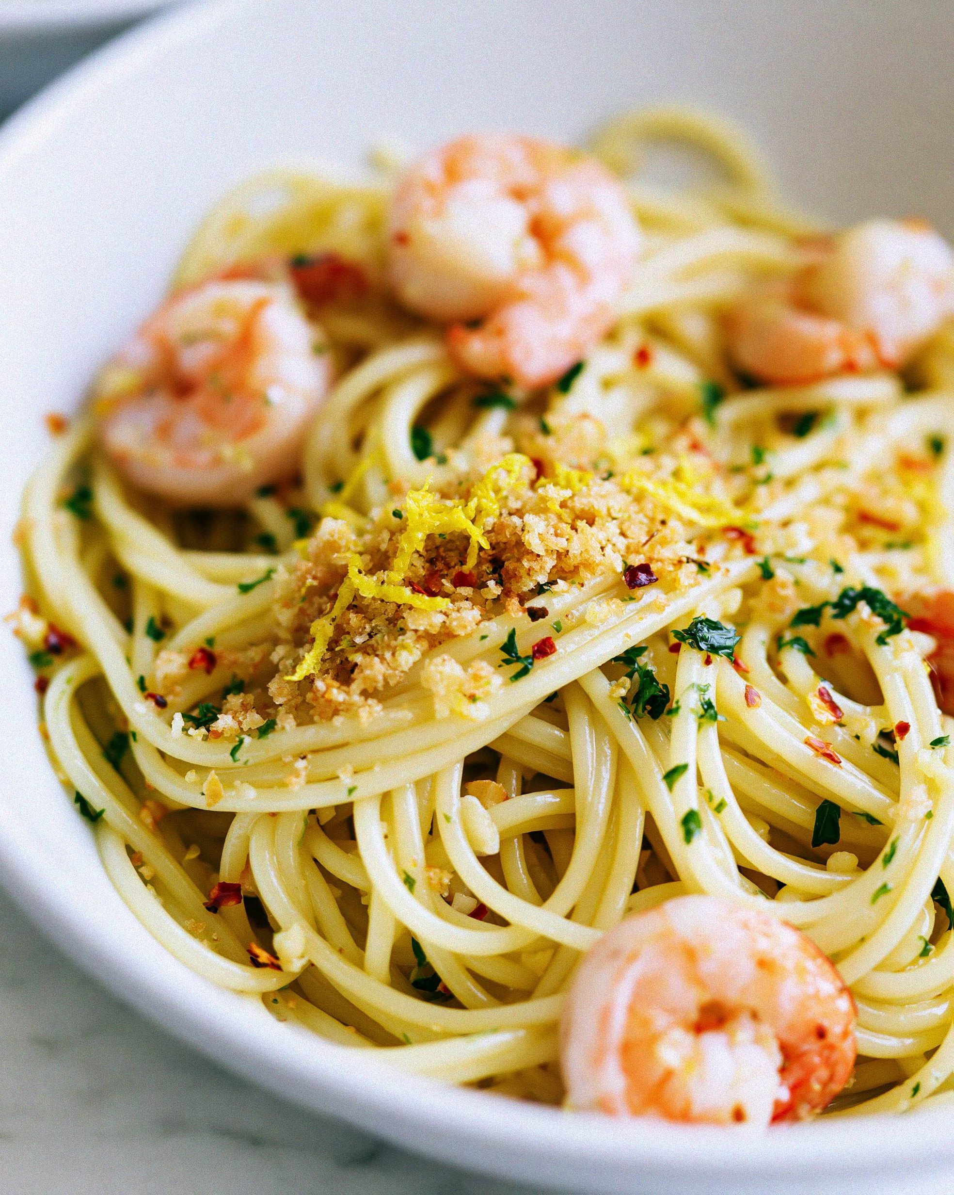 A serving of one-pan garlic butter shrimp pasta in a white bowl garnished with golden panko and fresh parsley