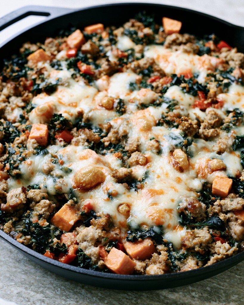 Melted pepper jack cheese bubbling over ground turkey and sweet potatoes in a skillet