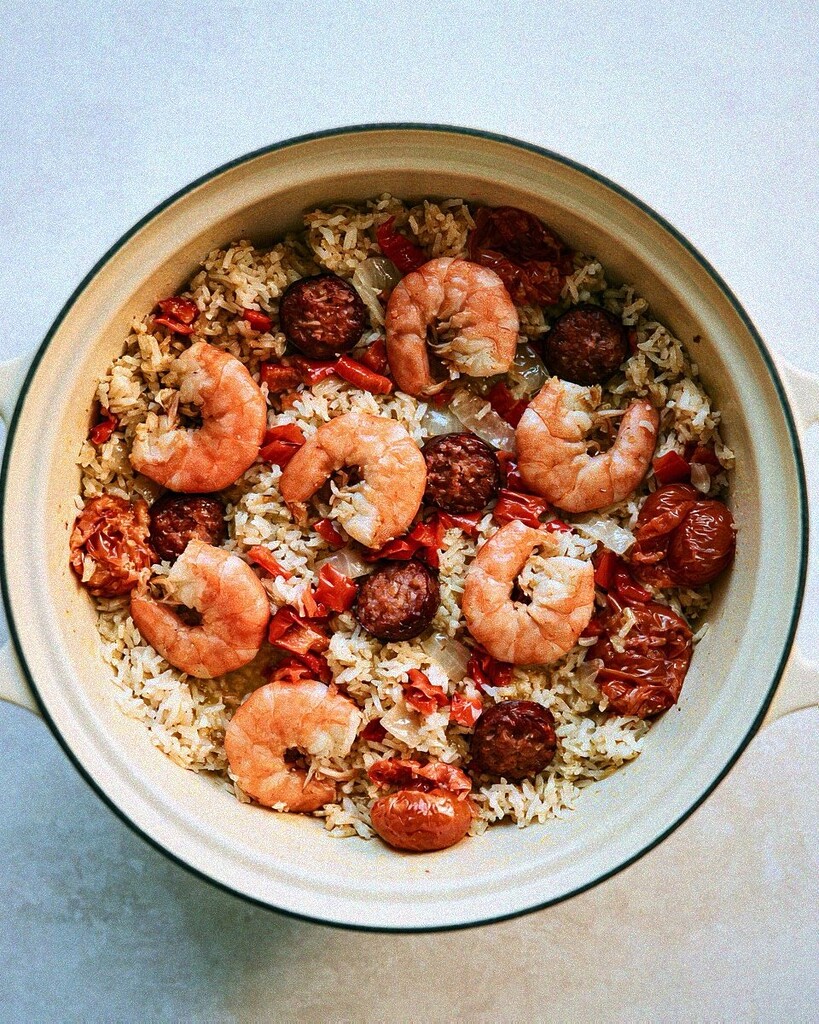 Pink, fully cooked shrimp resting on top of the spiced rice and tomatoes