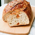 Sliced roasted garlic bread showing a soft, airy crumb and golden blistered crust