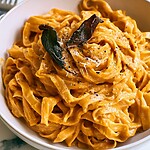 Brown Butter Sage Butternut Alfredo Fettuccine alfredo with bright orange butternut sauce topped with crispy sage and pepper in a light bowl