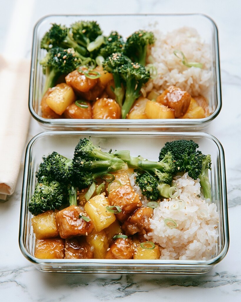 Two glass meal prep containers filled with coconut rice, chicken, and broccoli