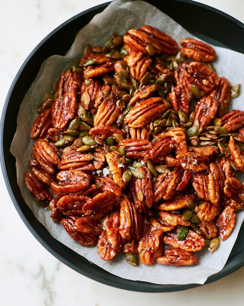Candied pecans and pumpkin seeds cooling on parchment paper