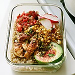 Chili-Lime Chicken Meal Prep Bowls That Stay Juicy Glass meal prep bowl with sliced chili-lime chicken, quinoa, corn, and half a spiced avocado with pumpkin seeds