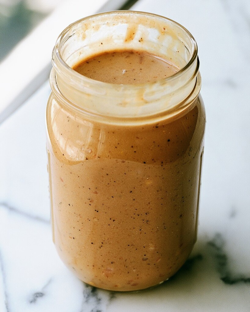Creamy brown apple butter vinaigrette emulsified inside a glass jar