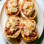 Roasted Garlic Spaghetti Squash Lasagna Boats Four roasted garlic spaghetti squash lasagna boats topped with melted cheese and golden panko on a light platter
