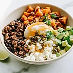 Sweet-Heat Hot Honey Beef and Sweet Potato Bowls Hot honey beef and sweet potato bowl garnished with avocado, cheese, seeds, and cilantro