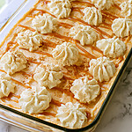 Pumpkin Spice Latte Tiramisu That Skips the Straining Pumpkin spice latte tiramisu in a glass baking dish topped with piped whipped cream, caramel drizzle, and a dusting of spice