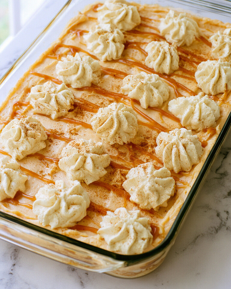 Pumpkin Spice Latte Tiramisu That Skips the Straining Pumpkin spice latte tiramisu in a glass baking dish topped with piped whipped cream, caramel drizzle, and a dusting of spice