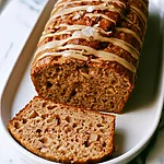 One-Bowl Apple Spice Cake with Deep Caramelized Flavor Sliced one-bowl apple spice cake on a white plate showing diced apples, nuts, and a shiny maple glaze