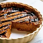 Gooey Brown Butter Peanut Butter Chess Pie Peanut butter chess pie baked in a ceramic dish with chocolate drizzle and flaky salt