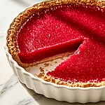 Cranberry-Lime Curd Pie with Cardamom Cream Chilled cranberry-lime curd pie in a brown crust with one slice removed