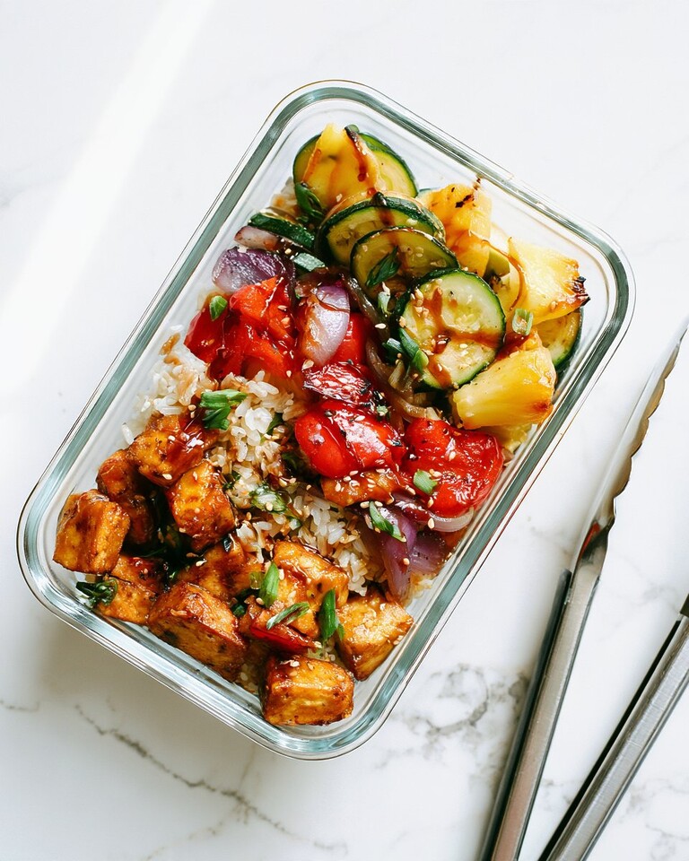 Charred Pineapple and Teriyaki Tofu Meal Prep Bowls for Four Days Glass meal prep container filled with rice, grilled teriyaki tofu, charred pineapple chunks, and grilled vegetables