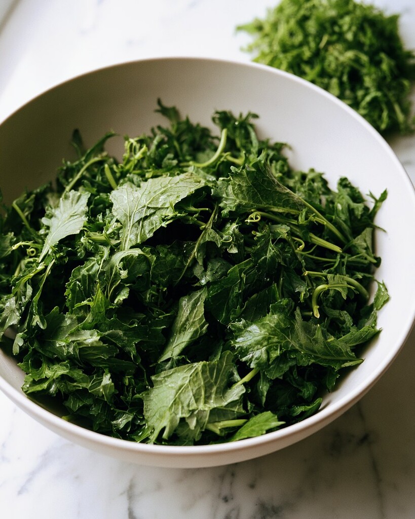 Dark glossy massaged baby kale in a white mixing bowl