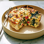 Baked high-protein tortilla quiche cut into sturdy slices on a serving plate with a golden, crispy cheese rim