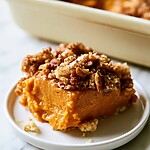 Fork resting near a plated serving of salted pecan pumpkin dump cake