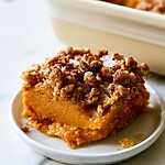 Salted Pecan Pumpkin Dump Cake with a Cobbler Crunch Square slice of salted pecan pumpkin dump cake showing smooth orange filling and crunchy topping on a white plate