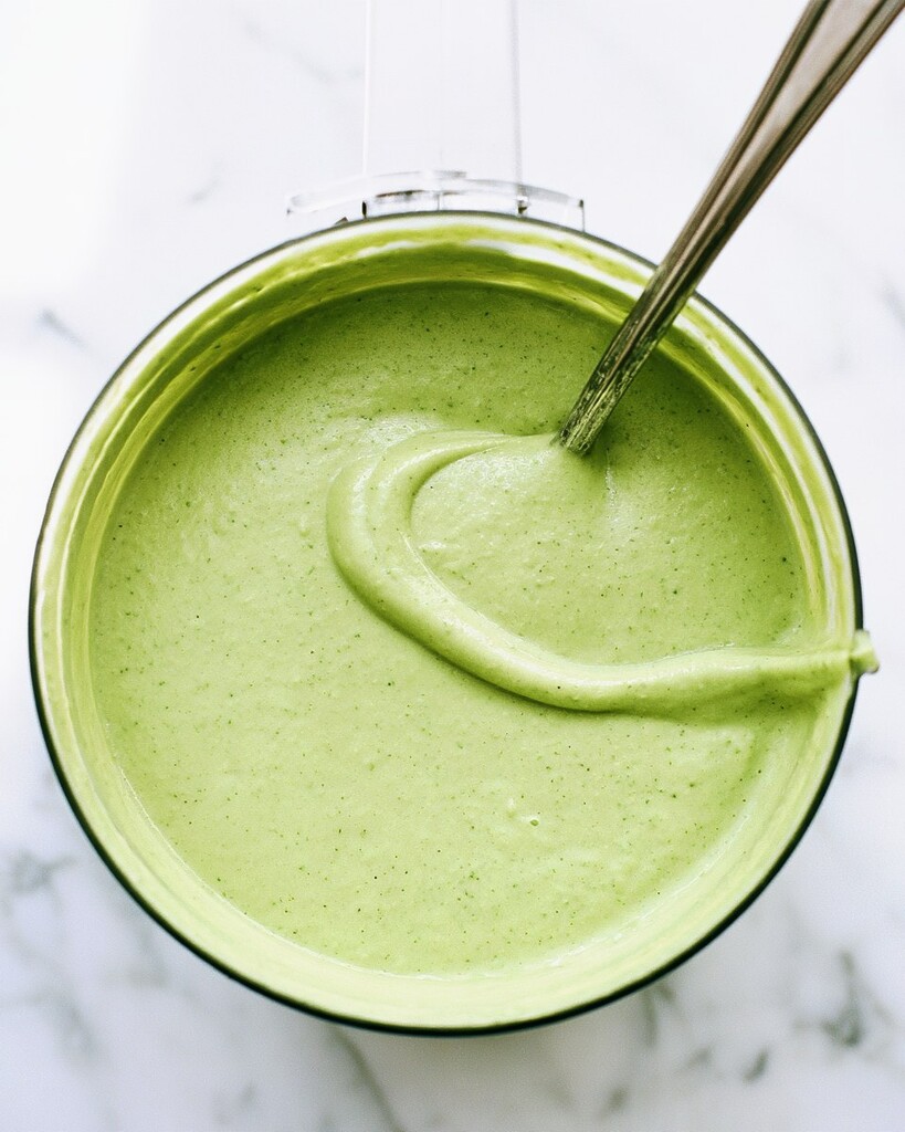 Light green jalapeño-avocado crema blending in a food processor