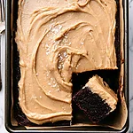 Dark Chocolate Espresso Sheet Cake with Brown Butter Frosting Overhead view of a dark chocolate espresso sheet cake with swirled brown butter frosting and a missing slice